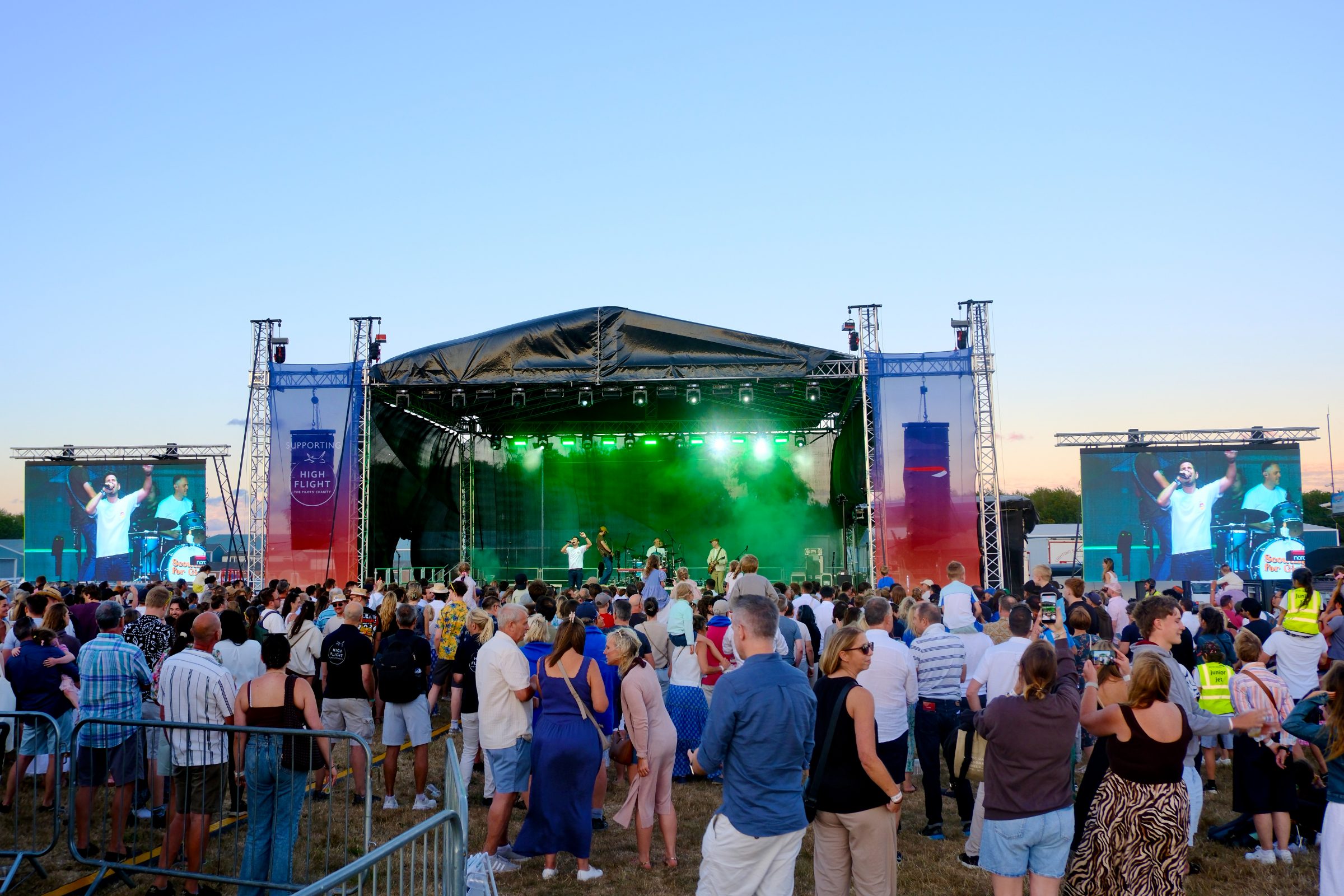 The main stage at the British Airways Flight Ops Summer Fly-In with IMAG screens either side and a High Flight charity banner