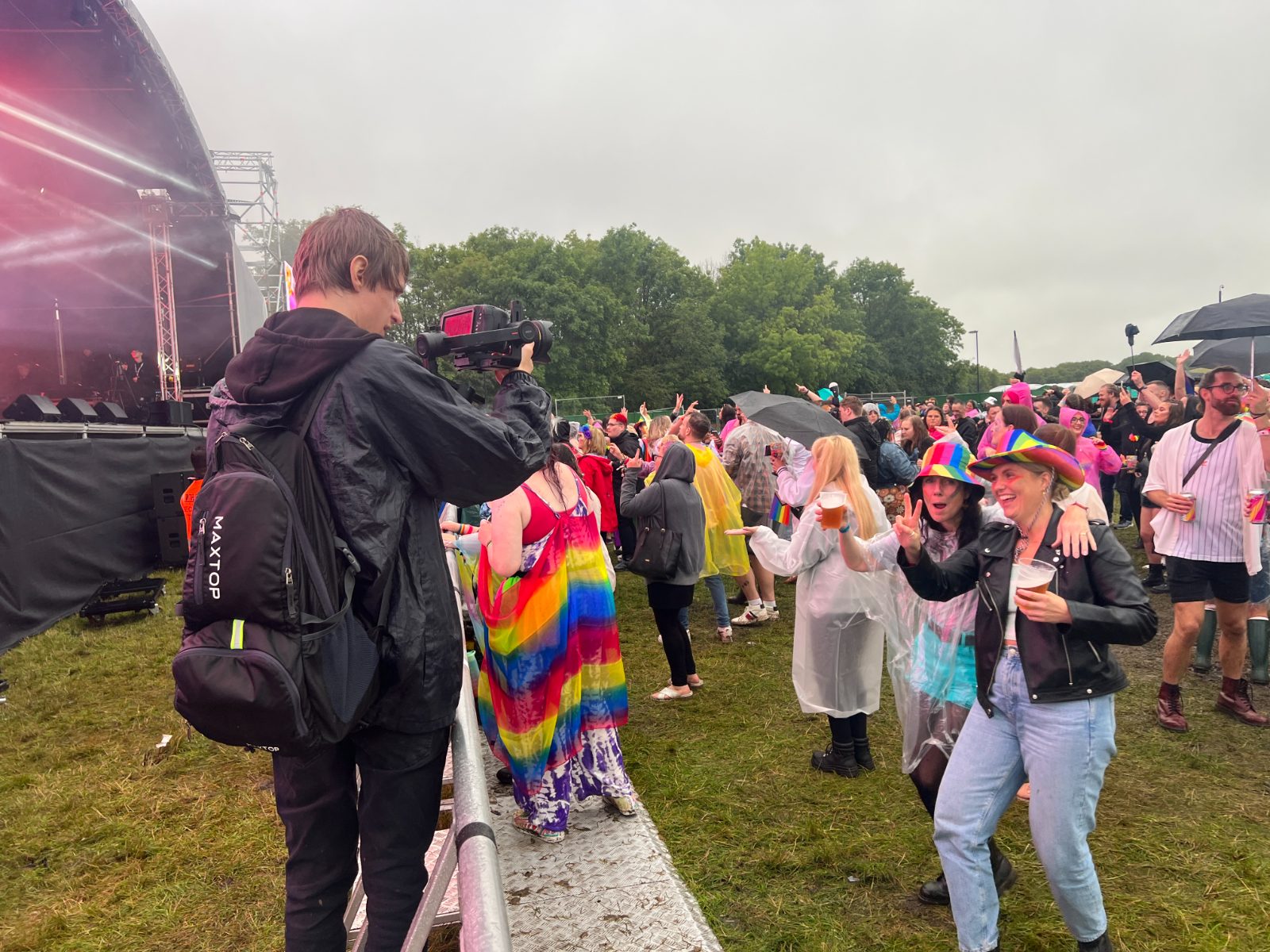 dwmedia camera operator on the barrier at Northern Pride, filming the crowd in the rain