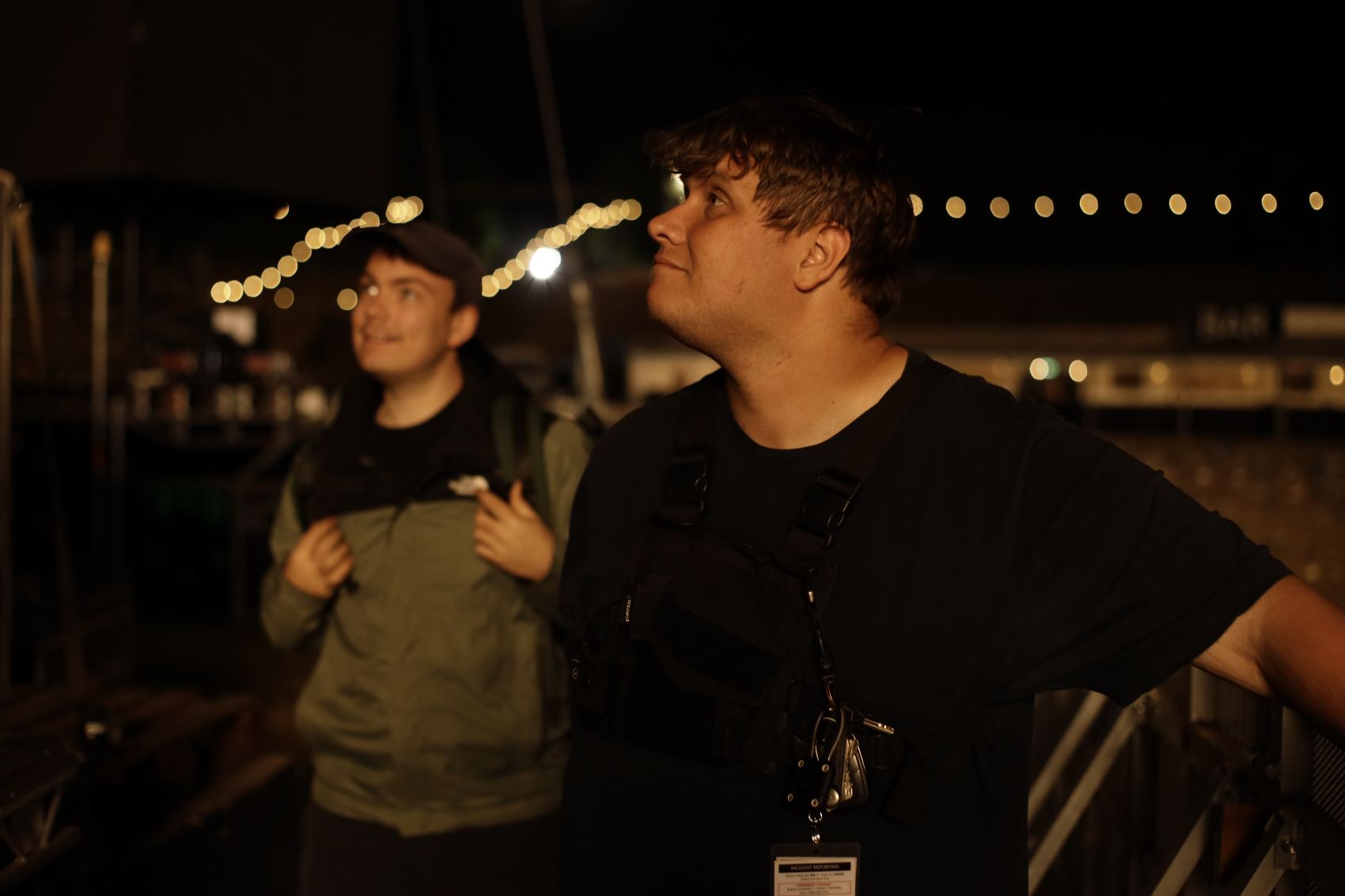 Two members of the dwmedia crew on site at an outdoor event at dusk